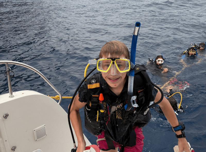 high school student in scuba gear on catamaran after dive on Caribbean voyage