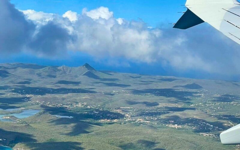 A view of a Caribbean island and the wing of a plane from taken from a Broadreach student flying unaccompanied minor