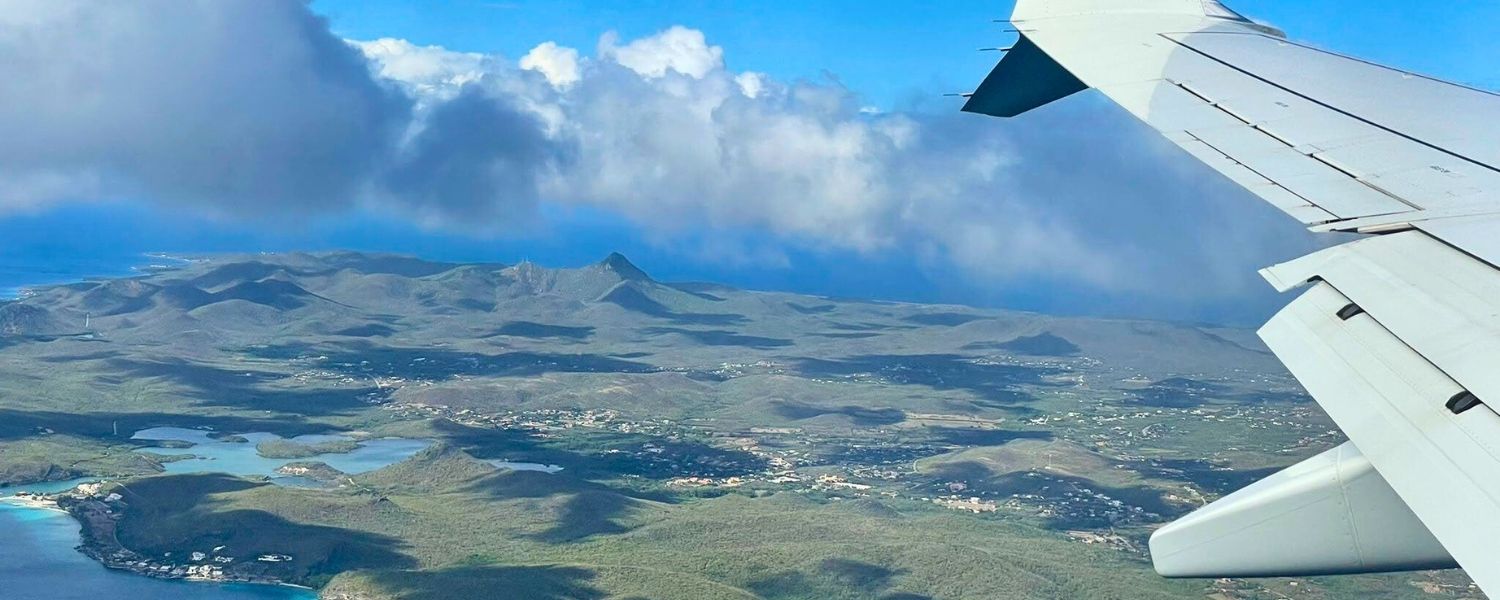 A view of a Caribbean island and the wing of a plane from taken from a Broadreach student flying unaccompanied minor